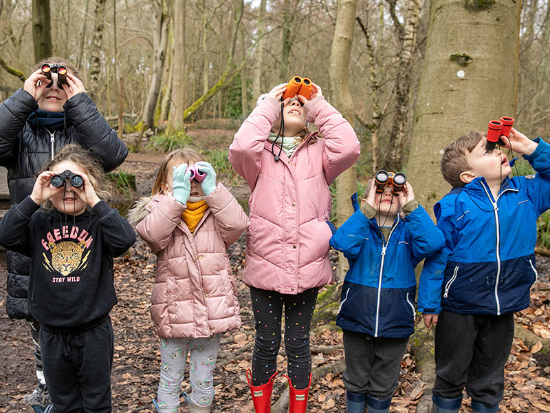 Group of young children with binoculars in Wellesley Woodlands